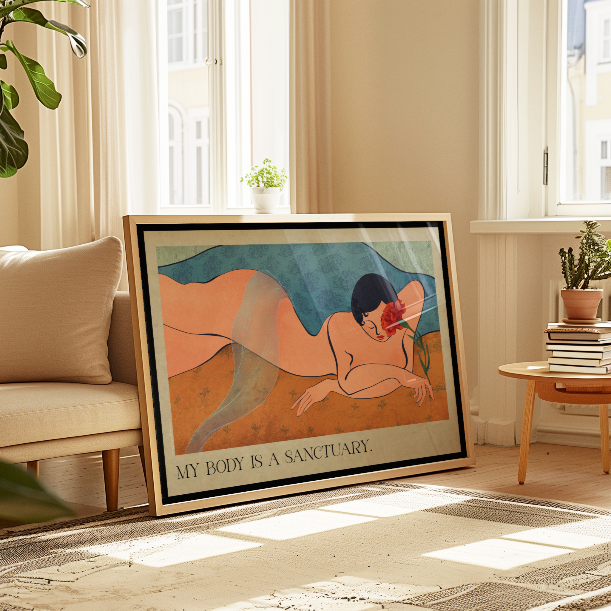 Framed art print leaning against a beige sofa in a sunlit living room. The print shows a stylized reclining nude figure with the text 'MY BODY IS A SANCTUARY' at the bottom, promoting self love.