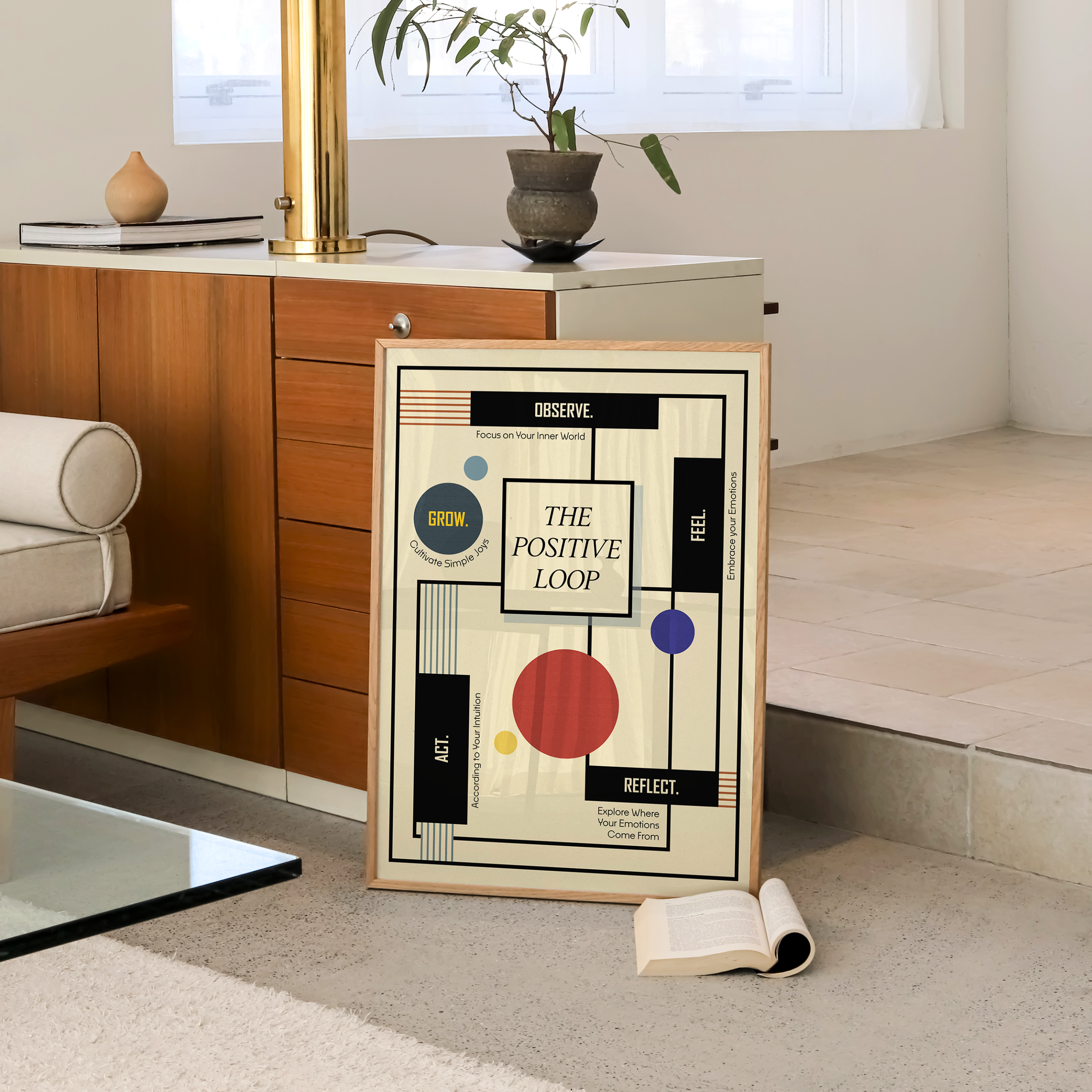 A framed Bauhaus-inspired geometric healing art print titled "The Positive Loop" styled against a wooden cabinet in a modern living room. Contemporary mental health wall art for therapy office decor, therapist and psychologist offices, counseling rooms, wellness clinics, life coaching offices, and mindful home decor.