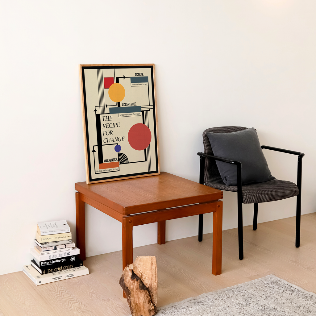 A framed Bauhaus-inspired healing art print with the quote "The Recipe for Change" hangs above a wooden desk in a modern home. A contemporary geometric wall art piece for therapy office decor, counseling spaces, and mindful interiors.