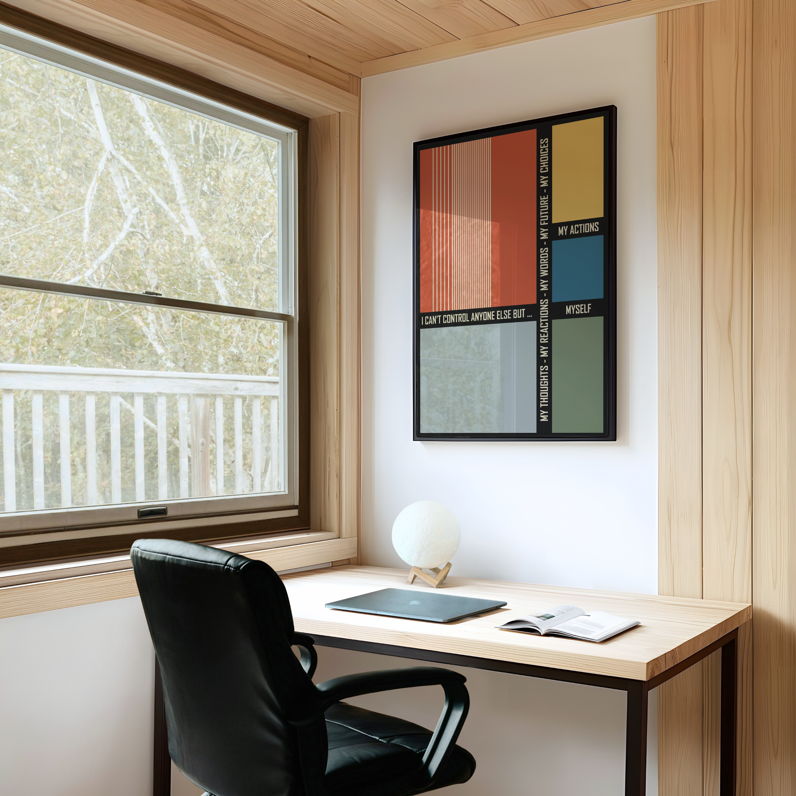 A framed abstract art print featuring geometric color blocks and a modern composition hangs on a white wall above a light wood desk with a black office chair. Displayed in a bright room with wood paneled walls and a large window, the artwork brings a sense of creativity, balance, and contemporary style to a home office, studio, or modern workspace.