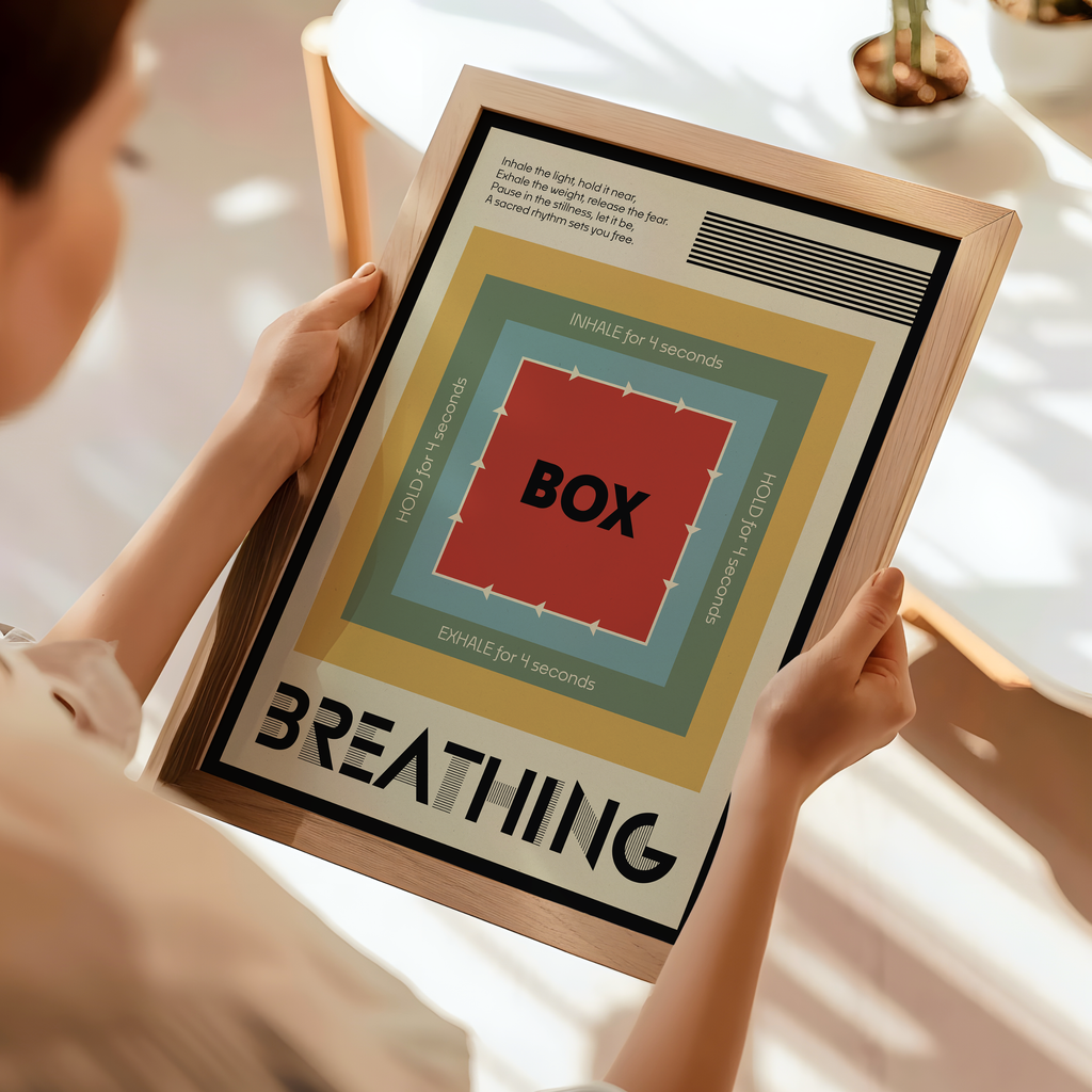 A person holds a framed poster featuring a minimalist breathing exercise graphic with concentric colored squares and the word 'BOXING' in the center, set in a bright, modern room.